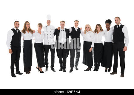 Volle Länge Portrait von zuversichtlich, das Personal im Restaurant stehend mit Arme um gegen den weißen Hintergrund Stockfoto