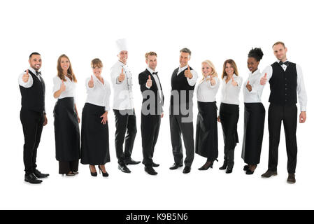 Volle Länge Portrait von zuversichtlich, das Personal im Restaurant stehen in der Zeile vor weißem Hintergrund Stockfoto