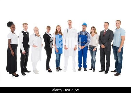 In voller Länge Porträt von Menschen mit verschiedenen Berufen stehen in der Zeile vor weißem Hintergrund Stockfoto