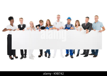 Group Portrait von Menschen mit verschiedenen Berufen halten leere Plakatwand vor weißem Hintergrund Stockfoto