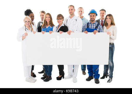 Group Portrait von Menschen mit verschiedenen Berufen halten leere Plakatwand vor weißem Hintergrund Stockfoto