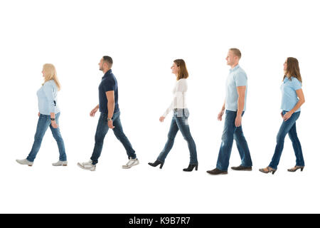 Volle Länge seitliche Ansicht von Männern und Frauen in der Warteschlange auf weißem Hintergrund Stockfoto