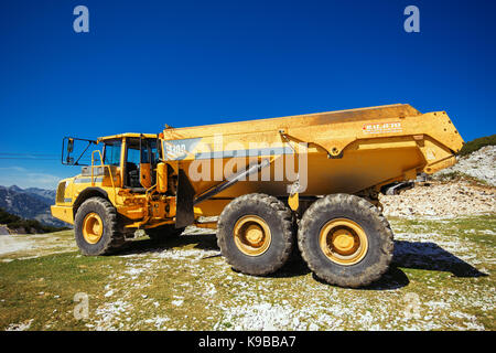 VOGEL BERG, Slowenien - 30. AUGUST 2017: Bau von Maschinen für das Zerkleinern von Stein, große Volvo Truck dumper Arbeiten am Hang Stockfoto