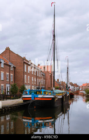 Restaurierte Binnenschiffe entlang der Beck/Kanal neben Stadthäusern an einem schönen Morgen in Beverley, Yorkshire, UK. Stockfoto