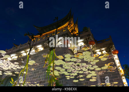 Ein Tor mit chinesischen Stil Pagode artisitically im Teich Wasser in der Nacht in der alten Stadt Lijiang, China wider Stockfoto