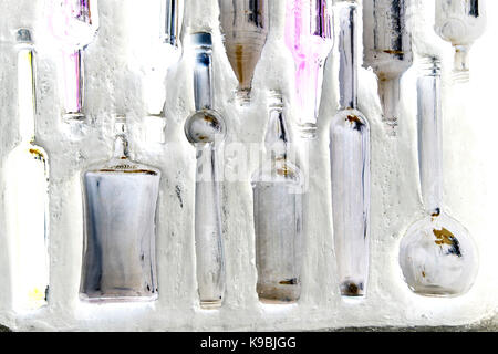 Flaschen in einer Wand - Glasflaschen eingebettet in einer weiß getünchten Wand Stockfoto