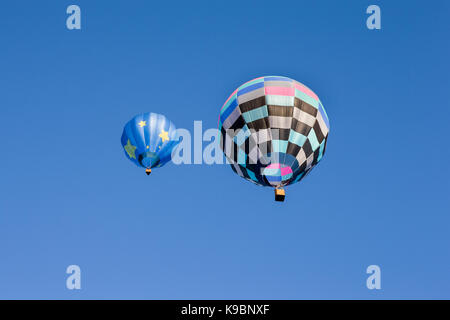 Paar bunte Heißluftballons gegen einen klaren blauen Himmel. Von unten gesehen. Stockfoto
