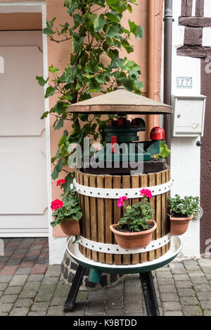 BERNKASTEL-KEUS, Deutschland - 5. Aug. 17: ein paar Blumen in einer wheel Barrow ist auf Anzeige außen ein Einzelhandelsgeschäft, um neue Kunden zu gewinnen. Stockfoto