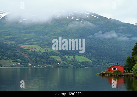 Red House Reflexion auf einem Norwegischen Fjord, Norwegen. Stockfoto