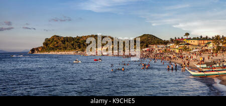 Touristen und Urlauber genießen Entspannen auf White Beach, Puerto Galera, Oriental Mindoro, Philippinen. Stockfoto