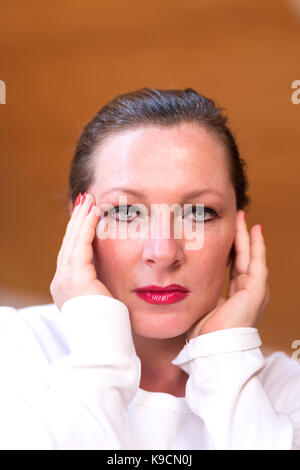Porträt einer Frau mittleren Alters leiden unter Kopfschmerzen in Ihrem Apartment im Dachgeschoss. Stockfoto