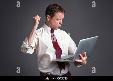 Ein Mittelalter Mann stehen und einen Laptop verwenden und fühle mich glücklich. Stockfoto