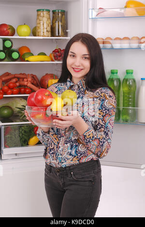 Gesunde Ernährung Konzept. Diät. schönen jungen Mädchen in der Nähe der Kühlschrank mit gesunden Nahrungsmitteln. Obst und Gemüse im Kühlschrank. veganes Essen Stockfoto