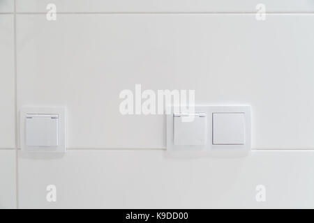 Moderne elektrische Schalter auf einer weißen Wand Fliesen. Stockfoto