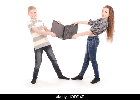 Junge und Mädchen kämpfen um einen Laptop, isoliert auf weißem Stockfoto