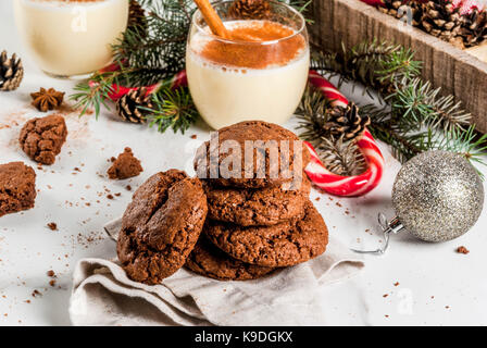 Schokolade Crinkle cookies für Weihnachten, mit eierlikör Cocktail, Zuckerstange, Weihnachtsbaum und Urlaub Dekoration, auf weissem Marmortisch, kopieren Raum Stockfoto