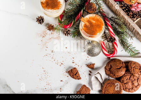 Schokolade Crinkle cookies für Weihnachten, mit eierlikör Cocktail, Zuckerstange, Weihnachtsbaum und Urlaub Dekoration, auf weissem Marmortisch, kopieren, um Platz zu Stockfoto