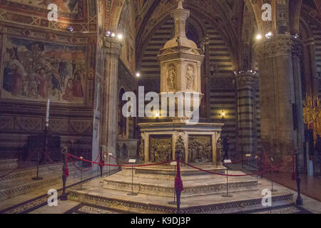 Italien, Siena - 26. Dezember 2016: Die Ansicht der Font in Siena Baptisterium, mit Marmor Wohnung und Statue von Jacopo Della Quercia, Panel von Ghiberti ein Stockfoto