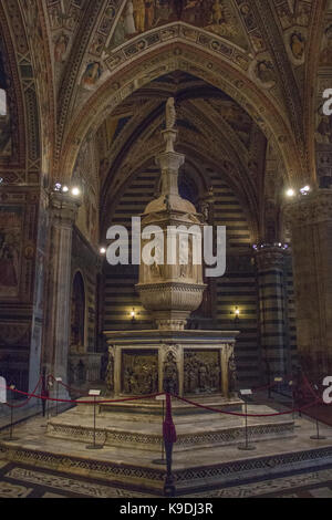 Italien, Siena - 26. Dezember 2016: Die Ansicht der Font in Siena Baptisterium, mit Marmor Wohnung und Statue von Jacopo Della Quercia, Panel von Ghiberti ein Stockfoto