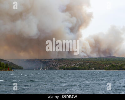 Waldbrand in Kroatien, Sommer Naturkatastrophe in der Nähe zum Nationalpark Krka, Sibenik Region, Boote und Yachten austretende Skradin Stadt aus dem Rauch Stockfoto