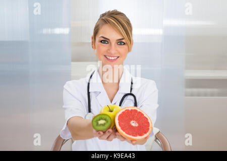 Portrait von Happy weiblich Ernährungsberater Holding Früchte Stockfoto