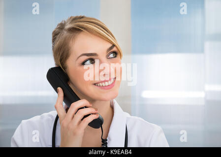Nahaufnahme der Glückliche Ärztin sprechen am Telefon Stockfoto