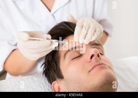 Junger Mann mit Botox Behandlung im Beauty Klinik Stockfoto