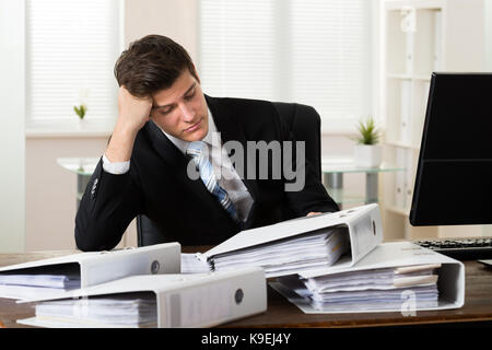 Jungen betonte Geschäftsmann mit Ordnern arbeiten im Büro Stockfoto