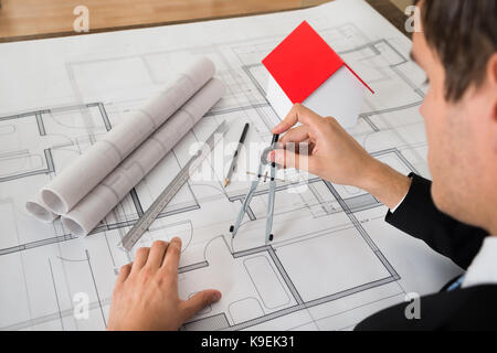 Nahaufnahme der männlichen Architekten mit Kompass auf Blueprint Papier Stockfoto