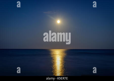 Vollmond über der Bucht Pinarello mit kühlen Reflexion auf das Meer Stockfoto