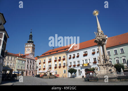 Marktplatz in Mikulov mit Uhrturm der Kirche und der Statue. Stockfoto