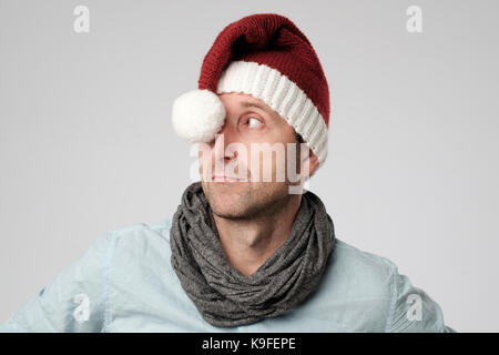 Entspannt cauasian reifer Mann, der Weihnachtsmann hat neben der Suche auf grauem Hintergrund Stockfoto
