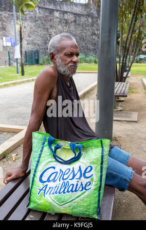 Fort-de-France, Martinique. Älterer Mann ruht auf einer Parkbank. Stockfoto