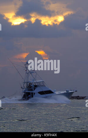 Ein tiefes Meer Sport Angeln boot Köpfe bei Sonnenaufgang in der Nähe der Stege in Port Aransas, Texas Stockfoto