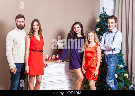 Weihnachtsfeier. Gruppe für junge Erwachsene Freunde Weihnachten genießen, Spaß haben und auf der Suche an der Kamera. Innen-, Studio shot Stockfoto