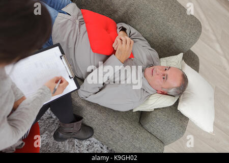 Mann auf dem Sofa liegend während der Psychotherapie Stockfoto