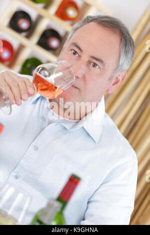 Gerne reifer Mann trinken Rosewein Stockfoto