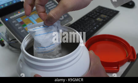 Chemischen Wissenschaftler öffnen weiß unbeschriftete Kunststofftank Kanister mit Chemikalien am Labortisch Stockfoto