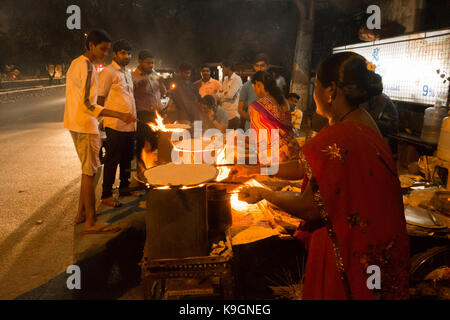 HYDERABAD, Indien-22 nd SEPTEMBER 2017. Indische Frauen bereiten Jowar Roti (Sorghum Mehl Fladenbrot) auf einem Holzfeuer kochen Ofen in Hyderabad, Indien. Sorghum Stockfoto