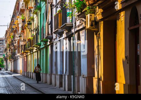 Valencia Spanien Stadt, Blick auf eine junge Frau, die allein durch eine bunte Straße in der Altstadt Barrio del Carmen Viertel von Valencia, Spanien. Stockfoto