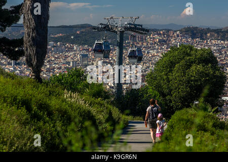 Zwei Kabinen der Port Vell Aerial Tramway fahren aneinander vorbei. Im Hintergrund ist die Stadt Barcelona, Barcelona, Spanien 2017. Stockfoto