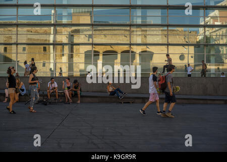 Menschen entspannen, spazieren gehen und Skateboarden in Plaça dels Ängels, Barcelona, Spanien 2017. Stockfoto