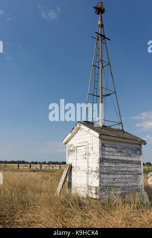 Pumpenhaus mit verwitterten Abstellgleis und die Überreste einer Mühle an der Spitze. Bienenstöcke im Hintergrund sind. Stockfoto