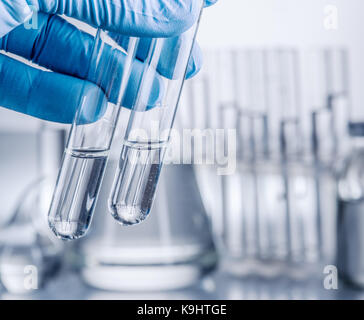 Labor-Becher in der Hand des Analytikers in Kunststoff-Handschuh. Stockfoto