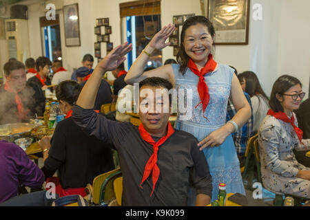 Peking, China, 23. Sep 2017. Chinesische Gäste tragen rote Schals der Jungen Pioniere in einem heißen Topf Restaurant in Peking, China, September 2017 23. Während niemand will eine Rückkehr in die Zeit der Turbulenzen, die China während der 1960er und 1970er Jahre ausgehalten, ein paar Restaurants der Leidenschaft der Revolution lebendig mit ihren kommunistischen halten - kitsch Dekor und sozialistischen Song-und-Tanz zeigt. Die chinesischen Zeichen an der Wand lesen ' Gut gut studieren, Tag für Tag bis" - Zitat von Mao. Lou Linwei/Alamy leben Nachrichten Stockfoto