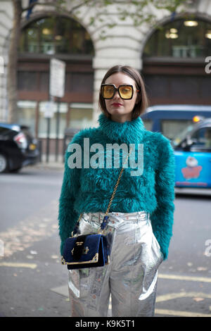 LONDON, ENGLAND - 15. September 2017 Schöne und stilvolle ein Mädchen in einem grünen pelzigen Pullover aus Fellimitat posiert während der London Fashion Week. Außerhalb Eudon Choi gemacht Stockfoto