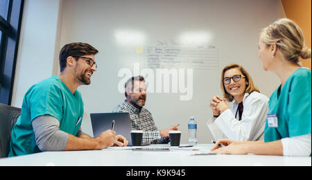 Happy medizinisches Team in einer Sitzung im Konferenzraum im Krankenhaus. Ärzte im Briefing im Krankenhaus. Stockfoto