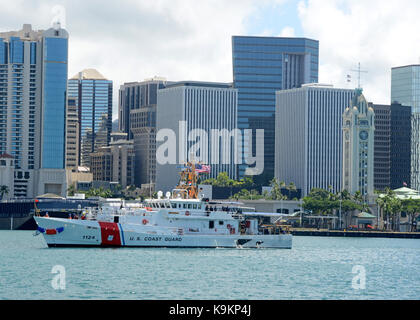 Das Patrouillenboot Oliver Berry (WPC 1124) vorbei Aloha Tower in Honolulu Hafen auf dem Weg zu Coast Guard Base Honolulu, Sept. 22, 2017. Stockfoto