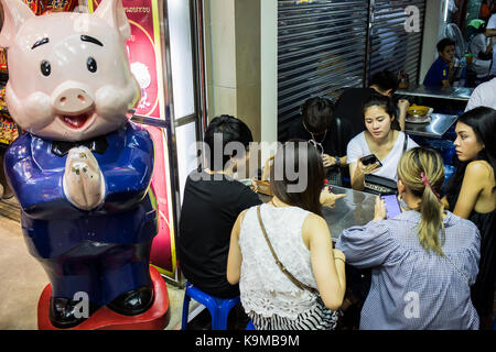 Frauen warten auf die Teller-Bestellung, Street Food Nachtmarkt, in Yaowarat Straße, Chinatown, Bangkok, Thailand Stockfoto