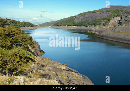 Llyn Peris in Snowdonia liegt in der Nähe von Llanberis. Dieser gletschersee wird von der ehemaligen Schiefergrube der Dinorwig flankiert und ist jetzt ein Reservoir. Stockfoto